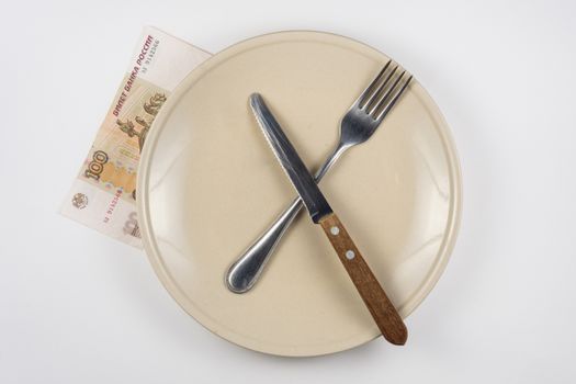 Empty plate with fork and knife, close is a hundred-ruble note, white background