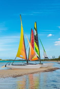 Small sailboats sitting on a sandbar in the caribbean.