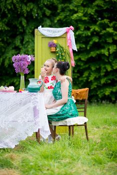 mother with daughter have a breakfast in the garden