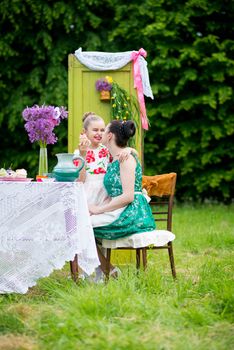 mother with daughter have a breakfast in the garden