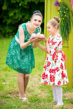 mother with daughter have a breakfast in the garden