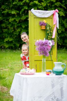 mother with daughter have a breakfast in the garden