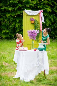 mother with daughter have a breakfast in the garden