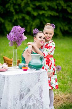 mother with daughter have a breakfast in the garden