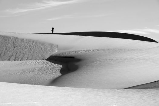 Life is the trip, lonely man enjoy calm scene on Vietnamese sand hill, sandhill with amazing shape in black and white tone in summertime, adventure travel in the choice of freedom young people