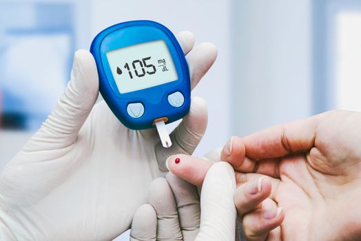 Doctor making blood sugar test in clinic for diabetes. 