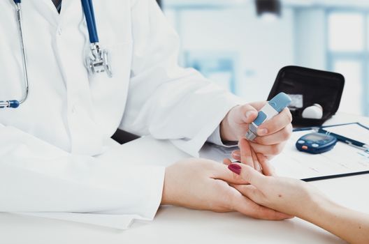 Doctor checking blood sugar level. doctor patient diabetes lancet glucometer blood glucose office concept