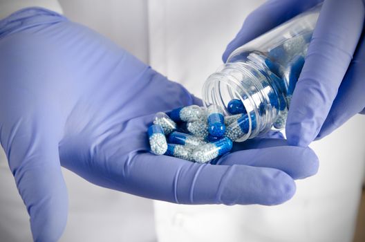 Person pouring out pills on hand. pill doctor hand pour capsule bottle closeup pills concept