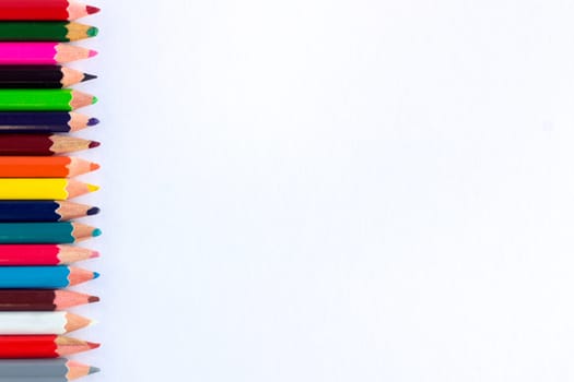White background for presentation with vertical colourful right border of multicoloured wooden pencils