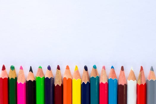 White background for presentation with horizontal colourful bottom border of multicoloured wooden pencils