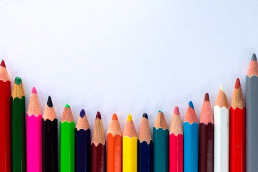 White background for presentation with round horizontal colourful bottom border of multicoloured wooden pencils