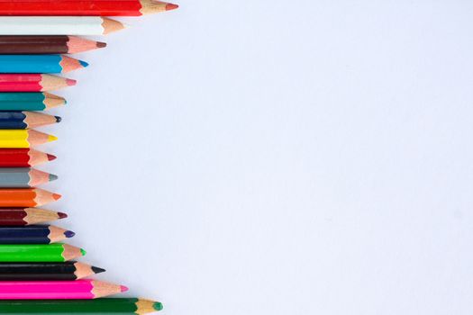 White background for presentation with vertical colourful right round border of multicoloured wooden pencils