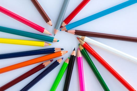 Colourful circle of wooden pencils on white background with copy space