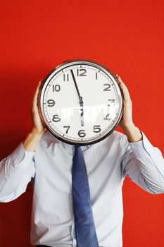 Man with wall clock on red background, deadline concept