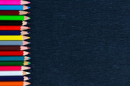 Black background for presentation with vertical colourful right border of multicoloured wooden pencils