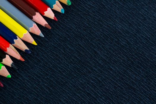 Black background for presentation with colourful right upper corner of multicoloured wooden pencils