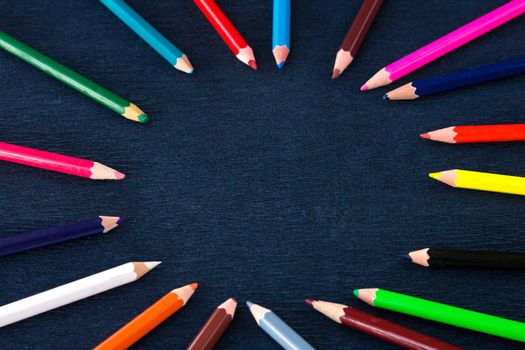 Black background for presentation slide with colourful wooden pencils with circle copy space