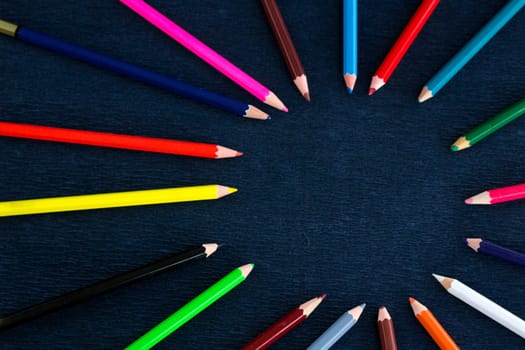 Black background for presentation slide with colourful wooden pencils with circle copy space