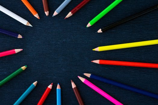 Black background for presentation slide with colourful wooden pencils with circle copy space