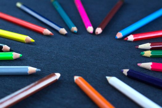 Black background for presentation slide with colourful wooden pencils with circle copy space