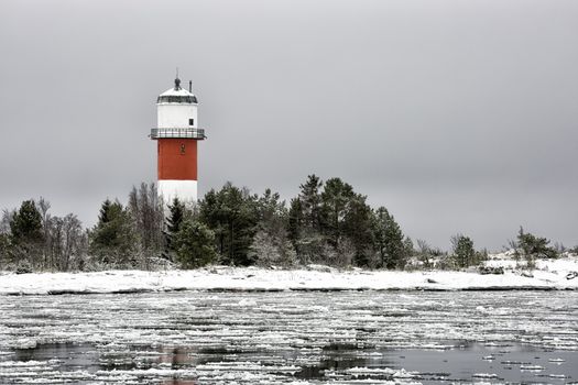 Light House with Icy Ocean and a cloudy sky.