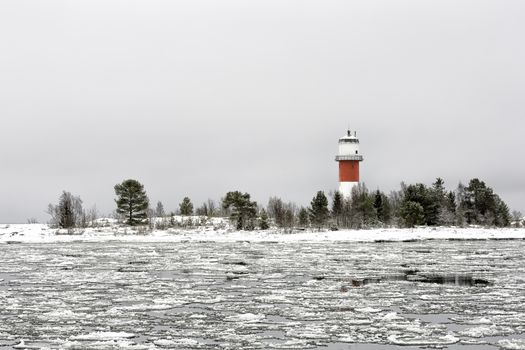 Light House with Icy Ocean and a cloudy sky.