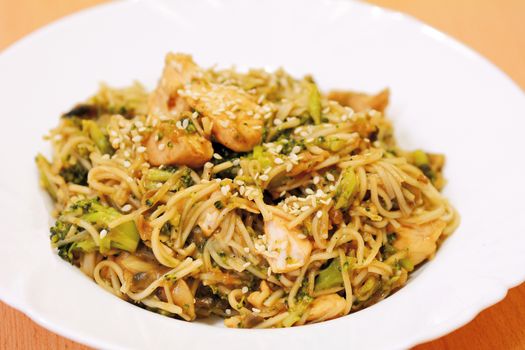 Chinese noodles with chicken meat, broccoli and vegetables.