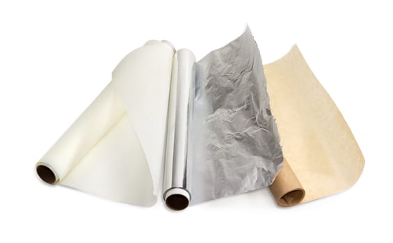 Two rolls of the various parchment paper and one roll of the aluminum foil for household use on a light background. 
