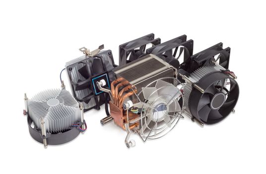 Several various active CPU coolers with fans and computer fans different sizes for use in a computer case on a light background
