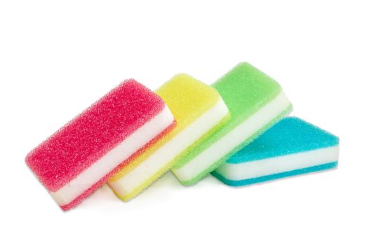 Several synthetic layered cleaning sponges with layer for more intense scrubbing different colors on a light background
