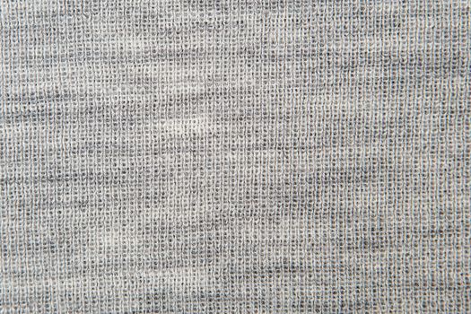 Close up on knit woolen fur texture. gray fluffy woven thread sweater as a background.
