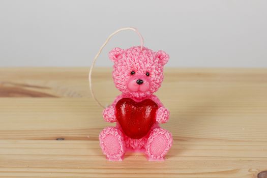 Funny Souvenir gift candles in the shape of teddy-bear with red heart. St. valentine's day.