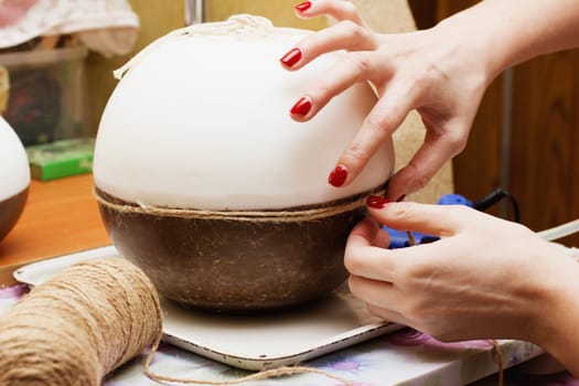 Female hands decorating handmade candles.