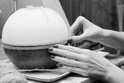 Female hands decorating handmade candles. Black and white photography