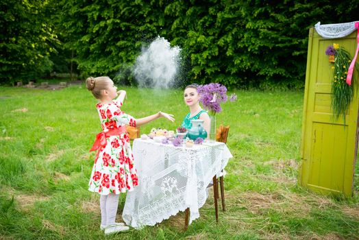 mother with daughter have a breakfast in the garden