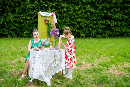 mother with daughter have a breakfast in the garden