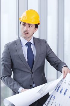 Architector in hardhat and business suit with construction plans