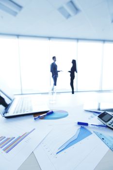 Financial reports, calculator and laptop on table in office