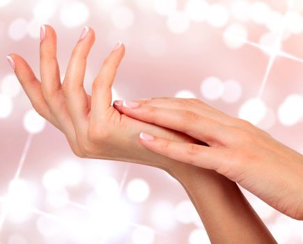 Beautiful woman hands against an abstract background with blurred lights