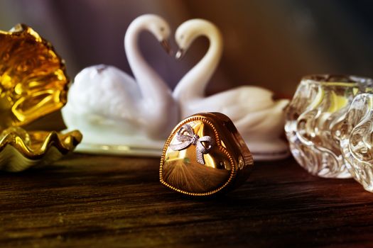 Closeup gold gift box of heart on old wooden table. gold heart-shaped box .Valentine's Day concept.