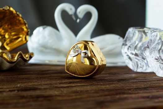 Closeup gold gift box of heart on old wooden table. gold heart-shaped box .Valentine's Day concept.