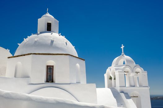 White orthodox church with bell tower. Fira, Santorini Greece. Copyspace