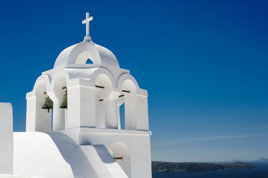 White orthodox church with bell tower. Fira, Santorini Greece. Copyspace