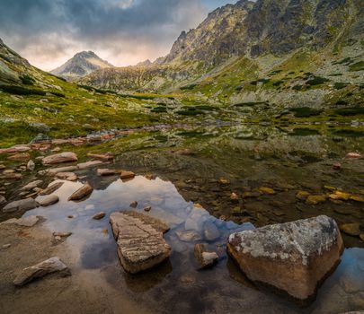 Mountain Lake Above Skok Waterfall with Rocks in Foreground and Strbsky Peak in Background at Sunset. Mlynicka Valley, High Tatra, Slovakia.