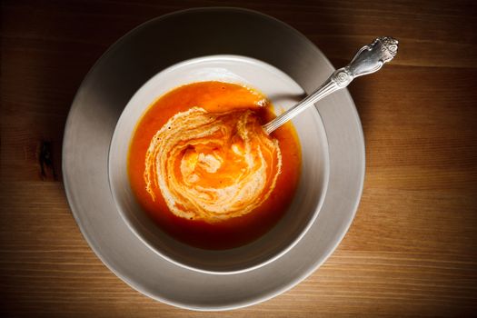 Pumpkin creme soup with a spoon served on a table