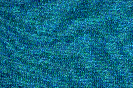 The background of the knitted fabrics of coarse woolen yarn blue and green shades.