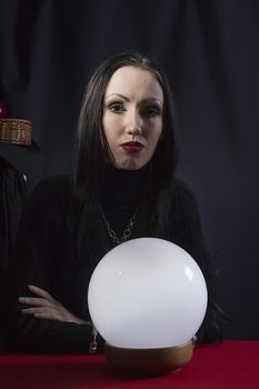 Fortune teller with a magic ball on a black background