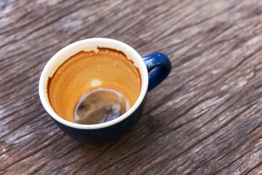 Empty cup of coffee with coffee espresso foam on olden wooden background 