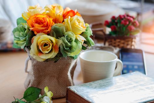 Colorful roses in a vase on table at office.