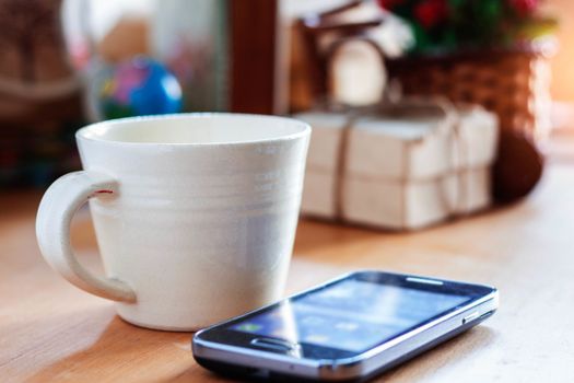 Cup of coffee and gift on the desk.